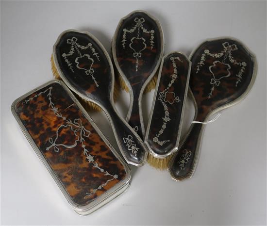 A George V silver and tortoiseshell pique trinket box and a similar four piece brush set.